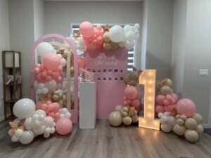 Pretty pink and cream balloon arch with light-up "1" and butterfly theme for a first birthday by Iconic Events Edmonton. Making Every Event in Edmonton Iconic.