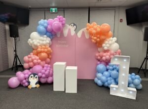 Cute pastel balloon setup with penguin theme and light-up "1" for a first birthday by Iconic Events Edmonton. Making Every Event in Edmonton Iconic.