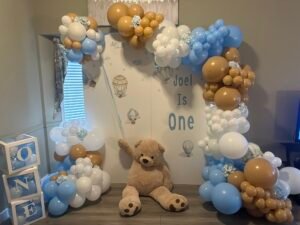 Blue, tan, and white hot air balloon theme with a giant teddy bear for Joel’s first birthday by Iconic Events Edmonton. Making Every Event in Edmonton Iconic.
